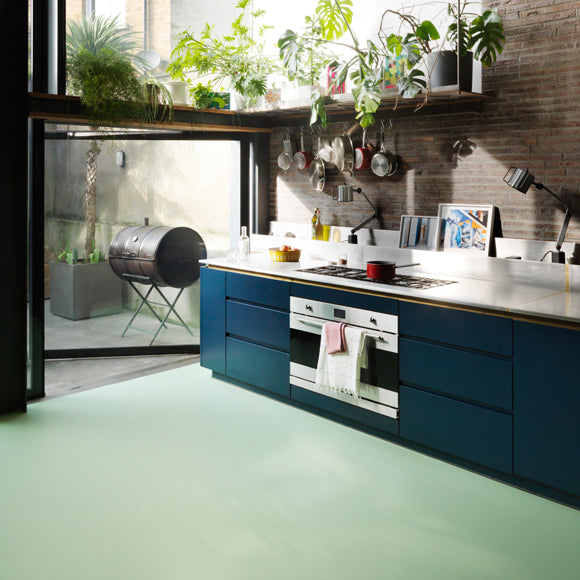 Pistachio green sheet vinyl flooring with dark blue kitchen units